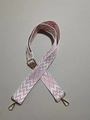 Detail eines pink-weißen Web-Schultergurts mit goldener Schnalle und geometrischem Muster - Rosa