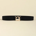 Ceinture élastique noire pour femme avec boucle métallique dorée sur une surface beige - Noir