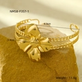 Macro shot of gold floral bangle with Cuban chain band on natural rock base - Flower Shape (NMSB-F357-1)