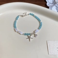 Vue détaillée du bracelet marin avec perles bleues, coquillages et étoile de mer argentée - Bracelet / Bleu-Blanc
