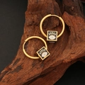 Gold stainless steel hoop earrings with square evil eye enamel charms on dark wood - Black