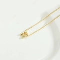 Minimalist gold letter R pendant necklace with delicate chain on white background - Letter R