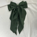 Elegant dark green satin bow hair clip with long ribbons on white fabric background - Verdant
