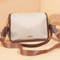 Bolso bandolera de nailon en color beige y marrón con herrajes dorados y correa ancha tejida - Caqui