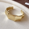 Polished wavy gold open bangle with minimalist geometric design on white texture - Dragon Bone Texture / Gold