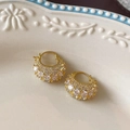 Detalle macro de pendientes de aro dorados con pavé de circonitas en bandeja cerámica - Pendiente de Aro Con Circonita en Pavé / Dorado