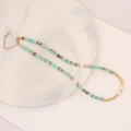 Beaded necklace with turquoise stones and white pearls on white marble tray - Translucent Green Turquoise Style