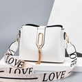 White minimalist bucket bag with gold tassel detail and a LOVE print wide shoulder strap - White