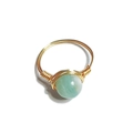 Detail of handmade gold wire-wrapped ring featuring a natural pale green stone bead - One Size / Amazonite