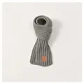 Detailed view of light gray knit scarf texture with embossed brown leather label - Kids / Gray
