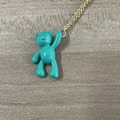 Minimalist gold chain necklace with a glossy cyan bear pendant on a wooden background - Large Bear / Lake Blue