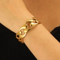 Macro shot of chunky gold leaf hollow cutout cuff bracelet on model wrist - Large Profile Chain Style (1414)