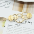 Golden alloy bow hair clip with textured circular motifs on card, length 6.3cm - Spiral Circles Gold