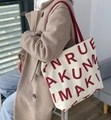 Large beige canvas tote bag with bold red lettering and matching red shoulder straps - KUNM Dark Red Letters