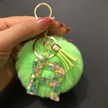 Detail of green fur pom pom and letter R resin keychain with colorful heart sequins - Letter R
