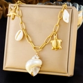 Detailopname van de boheemse gouden zeester- en schildpadhangers aan een schelpenketting - Zeester en Zeeschildpad Stijl (N3364)