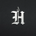 Detailed macro view of a silver stainless steel Old English letter H pendant with ring - Letter H