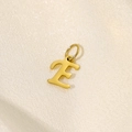 Makroaufnahme von goldenem Edelstahl-Buchstabe-E-Anhänger auf glattem Seidenhintergrund - Buchstabe-E / Gold