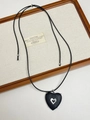 Close-up of black heart pendant with silver metal cutout on long woven cord necklace - Hollow Wood Heart (XL0920A)
