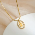 Detailed shot of gold plated oval pendant with inlaid zircon and letter V on silk - Letter V