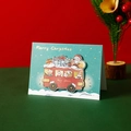 Mint green and red Christmas card featuring a 3D festive bus design with a cat and bear - Christmas Truck