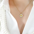 Collier en perles dorées avec pendentif rond en nacre et petit cœur porté au cou - Cœur en or