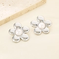 Gros plan détaillé de boucles d'oreilles fleurs argentées avec perle sur tissu beige - Style Acier Large (KE115791-GC)