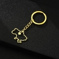 Close-up of golden Ukraine map pendant with a small heart on a black textured surface - Map with Heart / Gold