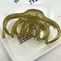 Translucent olive green large hair claw clip with glossy resin finish on white plate - Lazy Style Green
