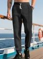 Detail of men's dark grey knit joggers featuring geometric jacquard texture and drawstring - Black