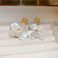 Dettaglio di orecchini a fiore in acrilico bianco con texture dorata su vassoio beige - Perno in argento-Bianco