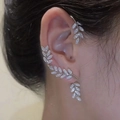 Silberne Blatt-Ohrklemmen mit weißen Zirkonia-Steinen für Damen am Model - Blatt Stil