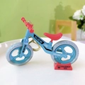 Creative mini blue balance bike keychain toy with red handle and seat on a red display stand - Bicycle Keychain - Gray