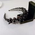 Detail of black beaded headband with floral elements on a clean white textured surface - Large Black Crystal
