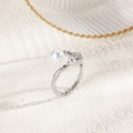 Macro detail of silver ring with irregular lava texture and a lustrous round white pearl - Silver