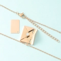 Gros plan d'un pendentif enveloppe or rose montrant une carte en métal amovible - Collier en Or Rose