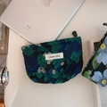 Dettaglio della pochette floreale verde scuro con etichetta simple wish e zip di chiusura - Base Nera con Fiori Verdi e Blu