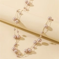 Detail of layered gold chain necklace featuring staggered champagne faux pearls - Caramel color