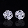 Silver flower stud earrings with brilliant zircon stones on reflective black background - White