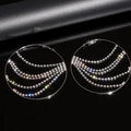 Detalle de pendientes de aro plateados con borlas de pedrería brillante en fondo negro - Estilo Aguja de Plata 925 / Plateado