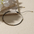 Detail of adjustable black woven bracelet with faceted dark beads and gold metal accents - Black/Multicolor