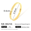 Détail d'un bracelet jonc en acier inoxydable doré avec motifs de fleurs et cristaux - Fleur à quatre pétales gravée (NB-B6256)