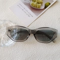 Cat eye sunglasses with translucent grey frames and dark lenses on a textured white background - Transparent Gray