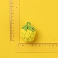 Handgehäkelter Erdbeeranhänger aus gelbem und grünem Garn mit Lineal zur Größenanzeige - Ananas Anhänger