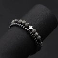 Detail view of double bead bracelets featuring a metal cross and lava tiger eye stones - 4mm Hematite + 6mm Map Stone