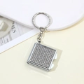 Macro shot of square rhinestone-encrusted keychain pendant with sparkling crystals - White