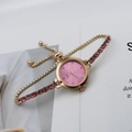 Close-up of women's quartz watch with pink rhinestone dial and adjustable slide buckle - Pink