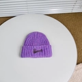 Detalle de gorro de punto acanalado morado con bordado de letras marrones sobre mesa - Talla Única (3-8 Años) / Morado