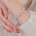 Elegantes Rosenperlen-Blumenarmband mit Zirkon-Akzenten auf weißem Manschettenhintergrund - Silber Stil / Rosa