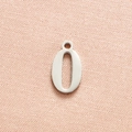 Macro shot of silver number 0 pendant in stainless steel on textured pink fabric - Steel Color Number 0
